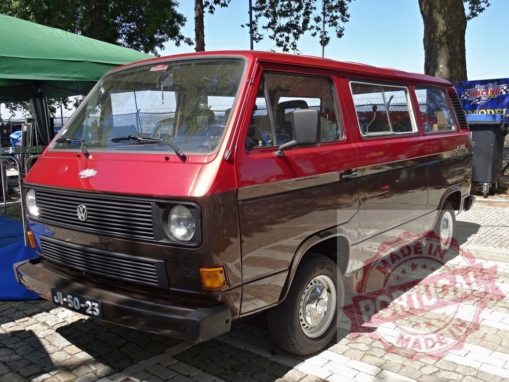 Volkswagen T3 Transporter van parked outdoors | Volkswagen T3 Transporter van featuring two-tone red and brown colors, parked on cobblestones - Realized with Pictrs.com