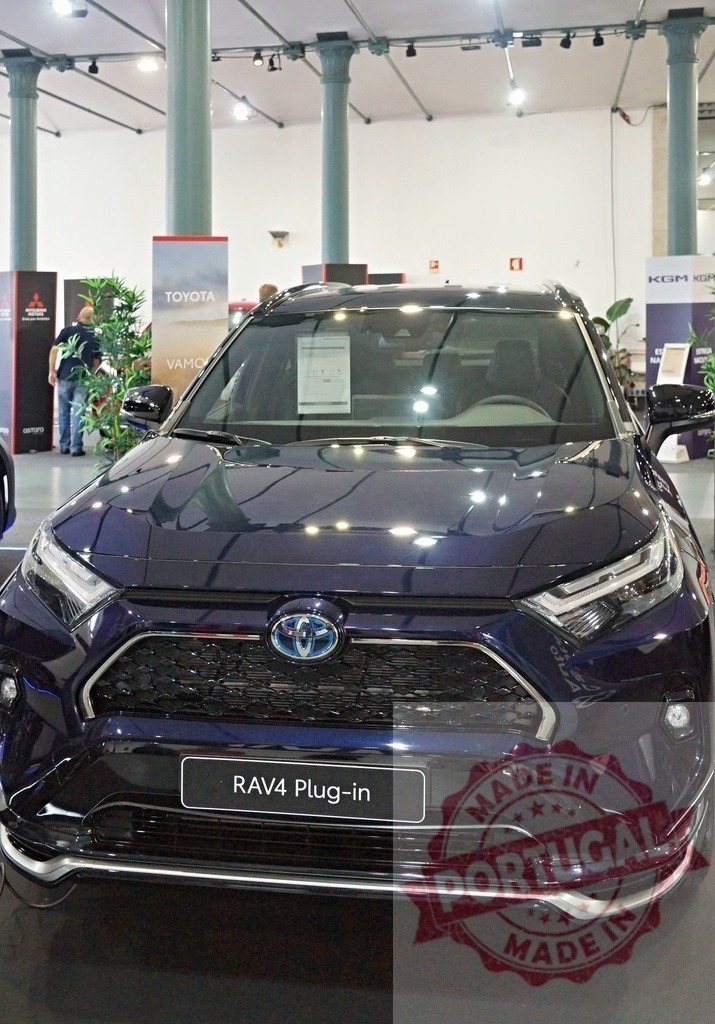Toyota RAV4 Plug-in hybrid car at auto show exhibition | Toyota RAV4 Plug-in hybrid SUV displaying new automotive technology at an indoor car show - Realized with Pictrs.com