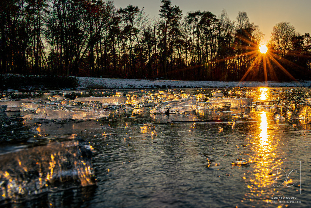 Kristallstunden – Licht trifft Eis | Dieses stimmungsvolle Wintermotiv wurde bei Sonnenuntergang an einem gefrorenen See aufgenommen. Die Kombination aus kristallklarem Eis, goldener Lichtreflexion und winterlicher Landschaft schafft ein visuelles Kunstwerk voller Ruhe und Tiefe. - Realisiert mit Pictrs.com