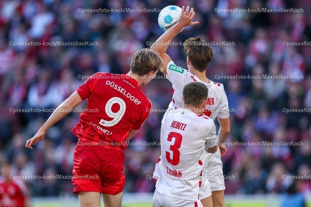 1FC23022501056 | 23.02.2025, Fußball, 1. FC Köln - Fortuna Düsseldorf, 2.. Fußball Bundesliga, 23. Spieltag, RheinEnergie-STADION, Saison 2024 2025: Vincent Vermeij (Fortuna Düsseldorf #9) im Kopfball Zweikampf gegen Dominique Heintz (FC Köln #3) und Joel Schmied (FC Köln #2) -  Joel Schmied (FC Köln #2) mit der Hand offensichtlich am Ball. - Handelfmeter Elfmeter HandspielDFB regulations prohibit any use of photographs as image sequences and or quasi-video.