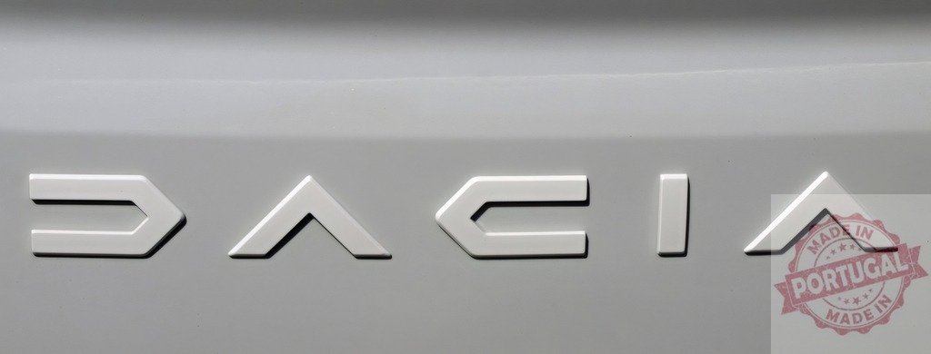 Dacia brand name on car closeup with geometric letters | Dacia nameplate appearing on a vehicle, showing modern automotive branding - Realisiert mit Pictrs.com