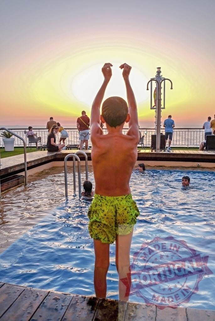 Boy preparing to jump into cruise ship swimming pool | Boy standing at the edge of a swimming pool on a cruise ship at sunset - Realized with Pictrs.com