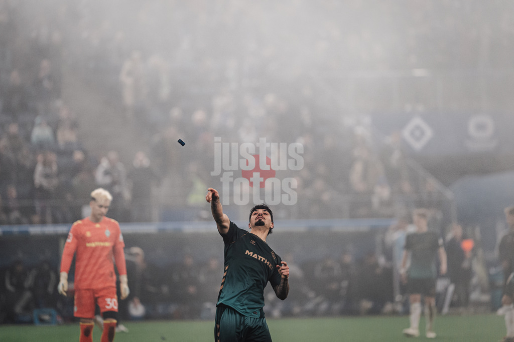 Fußball | Männer | Saison 2025/2026 | 1. Fußball-Bundesliga | 13. Spieltag | Hamburger SV vs. SV Werder Bremen | 07.12.2025 | Cameron Puertas (#18, SV Werder Bremen) entsorgt Pyrotechnik Feuerwerk der HSV Fans