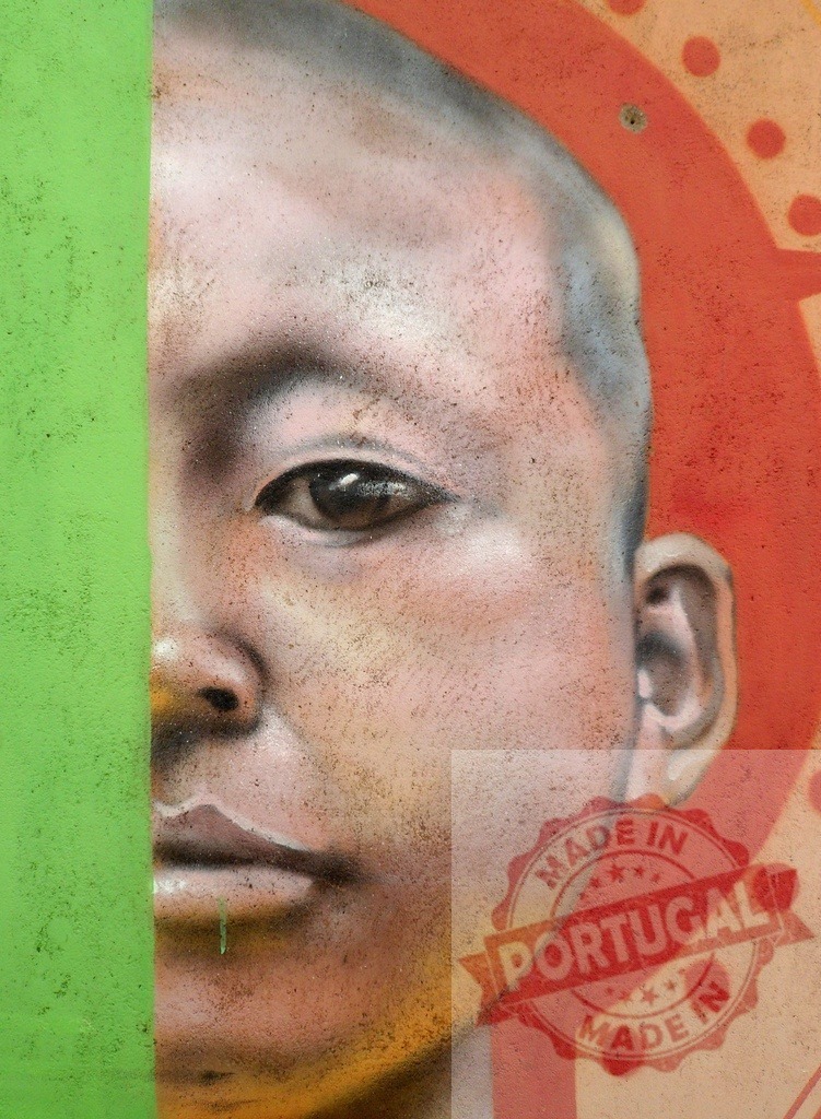 Boy portrait street art graffiti mural painting | Street art mural depicting a young boy's face, merging with a green wall and orange background - Realisiert mit Pictrs.com