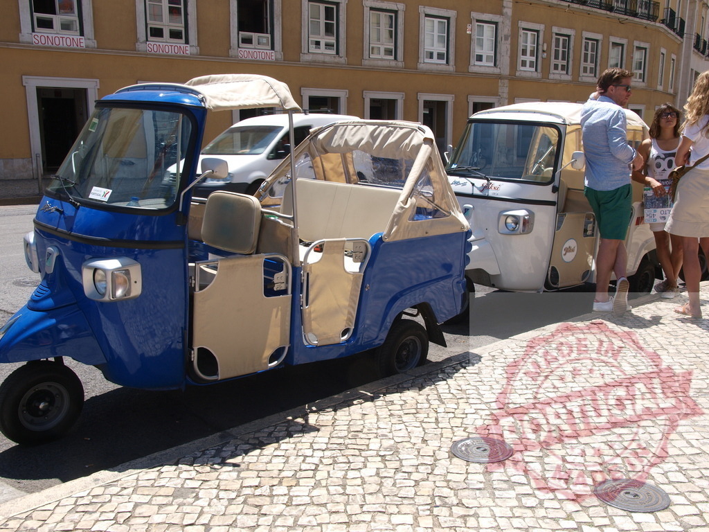 Tuk-tuks waiting for tourists on a historic city street offering rides | Blue and white tuk-tuks parked on cobblestone street in Lisbon Portugal - Realisiert mit Pictrs.com
