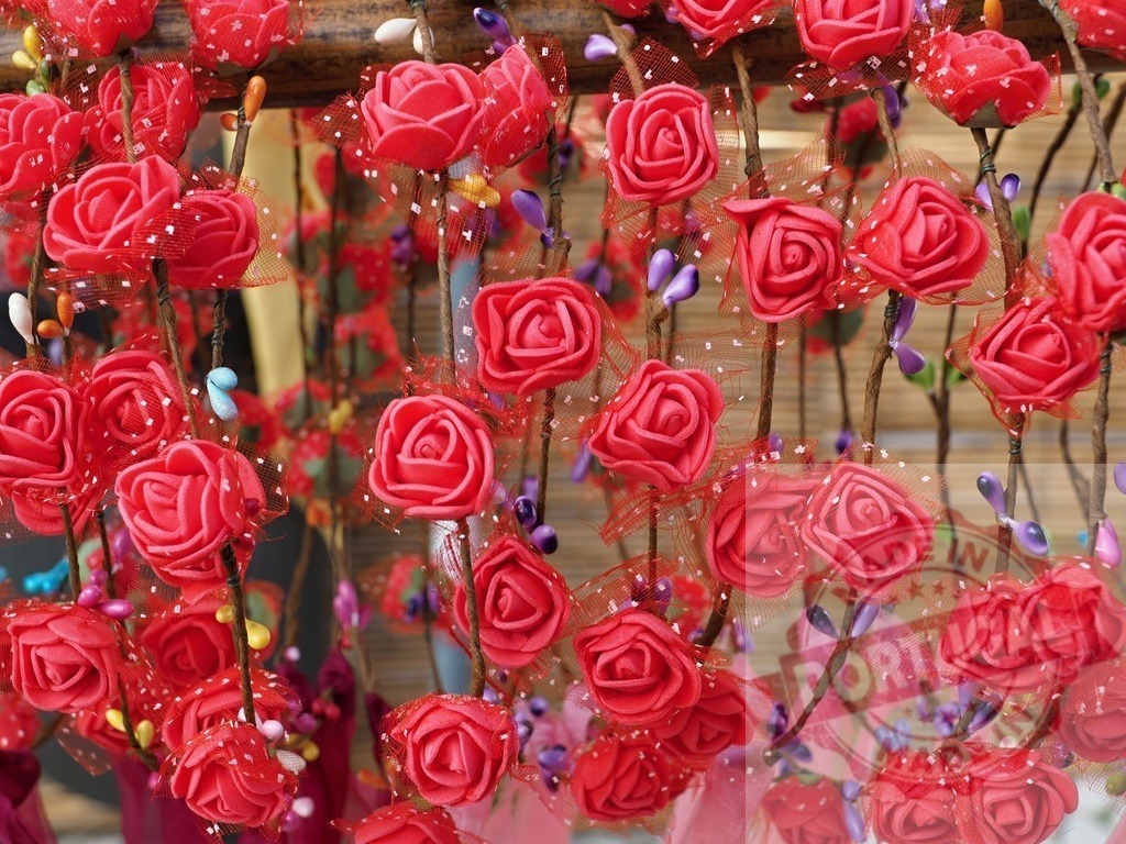 Red artificial roses decorating a creative display | Red artificial roses on branches forming a decorative display - Realized with Pictrs.com