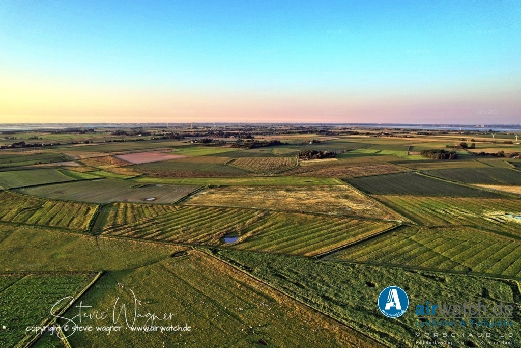 Luftbild Nordstrand, LangerDeich, Dreisprung, Püttenweg, Trendermarsch, Husumer Bucht | Luftbild Nordstrand, LangerDeich, Dreisprung, Püttenweg, Trendermarsch, Husumer Bucht - Der Trendermarschkoog befindet sich im Westen der Insel Nordstrand und grenzt an das Wattenmeer. Er ist nach der ehemaligen runden Insel Trendermarsch benannt, die nahe Alt-Nordstrand lag und bereits im 16. Jahrhundert angeeicht wurde. Die Eindeichung des Trendermarschkoogs erfolgte 1663 nach der schweren Sturmflut von 1634, die den westlichen Teil des Polders zerstörte und in eine Tidefläche verwandelte.