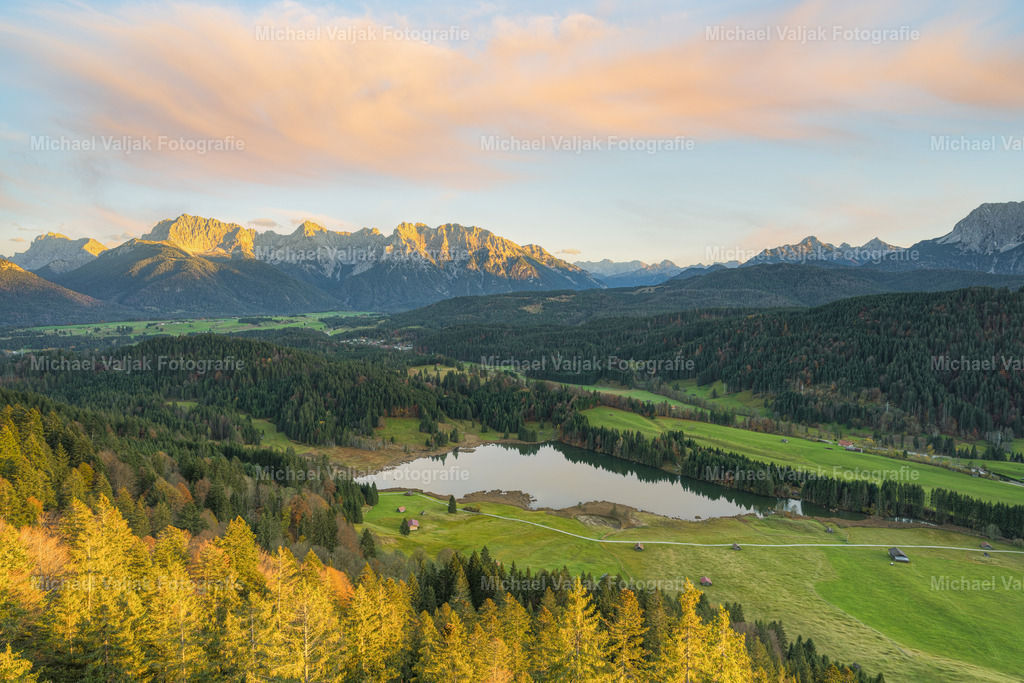 Blick über den Geroldsee | Blick am Abend über den Geroldsee in Richtung Karwendelgebirge. Die letzten Sonnenstrahlen des Tages treffen auf die Berggipfel und die Bäume im Vordergrund. - Realisiert mit Pictrs.com
