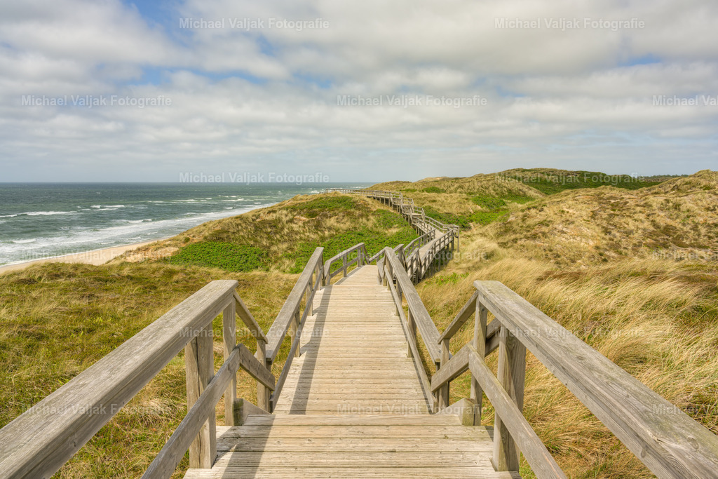 Steg durch die Dünen in Wenningstedt | Ein Spaziergang durch die Dünen in Wenningstedt auf Sylt bietet eine erfrischende Abwechslung vom Alltag. Die sanften Hügel, die grünen Gräser und der Himmel laden zum Verweilen und Genießen ein. Die salzige Meeresbrise weht einem um die Nase und lässt einen die Sorgen vergessen. Die Dünen sind ein wichtiger Lebensraum für viele Pflanzen und Tiere, die sich an die besonderen Bedingungen angepasst haben. Sie schützen auch die Insel vor Sturmfluten und Erosion. Ein Besuch in den Dünen ist immer ein Erlebnis, das man nicht so schnell vergisst. - Realisiert mit Pictrs.com