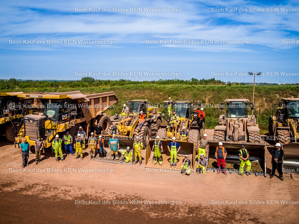 Mammendorf Mannschaft-0052 | Zum Abschluss der Baustellendokumentations-Galerie zeigt dieses Gruppenfoto die Mannschaft des Steinbruchs Mammendorf gemeinsam mit ihren großen Baumaschinen. Radlader und Muldenkipper bilden die beeindruckende Kulisse für die Mitarbeiter des Steinbruchbetriebs. Das Foto entstand unabhängig von der zuvor gezeigten Dokumentation über den Aufbau der neuen Brecheranlage, passt aber als Abschluss besonders gut: Es zeigt die Menschen und Maschinen, die hinter dem täglichen Betrieb eines modernen Steinbruchs stehen.Die Aufnahme vermittelt einen persönlichen Eindruck vom Arbeitsalltag im Steinbruch und bildet einen besonderen, etwas anderen Abschluss der Galerie.Die Aufnahme ist Teil des Mitteldeutschen Bildarchivs von Luftbildfotograf Steffen Lehmann. - Realisiert mit Pictrs.com