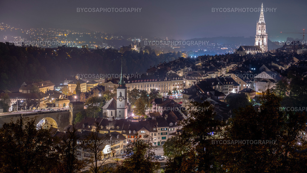 Bern by Night _ Old Town Lights | Ein faszinierendes Nachtpanorama der Schweizer Hauptstadt Bern, das die charmante mittelalterliche Altstadt in warmes Abendlicht taucht. Das ikonische Berner Münster ragt über die Dächer, während die sanft leuchtenden Straßen und der zarte Dunst Tiefe, Atmosphäre und zeitlose Schönheit verleihen.Dieser FineArt-Druck bringt Raffinesse, Eleganz und historischen Charme in jeden Raum – ideal für moderne Wohnungen, Büros und Liebhaber europäischer Architektur. - Realisiert mit Pictrs.com