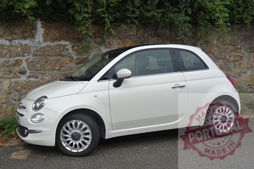 White Fiat 500 compact city car parked | White Fiat 500 compact car parked on asphalt next to an old stone wall - Realisiert mit Pictrs.com