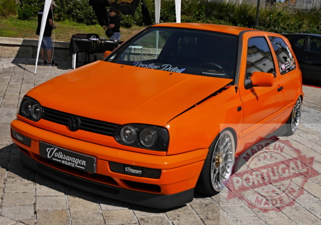 Custom orange Volkswagen Golf Mk3 hatchback at car show | Custom orange Volkswagen Golf Mk3 displaying a tuned appearance at an outdoor event - Realized with Pictrs.com