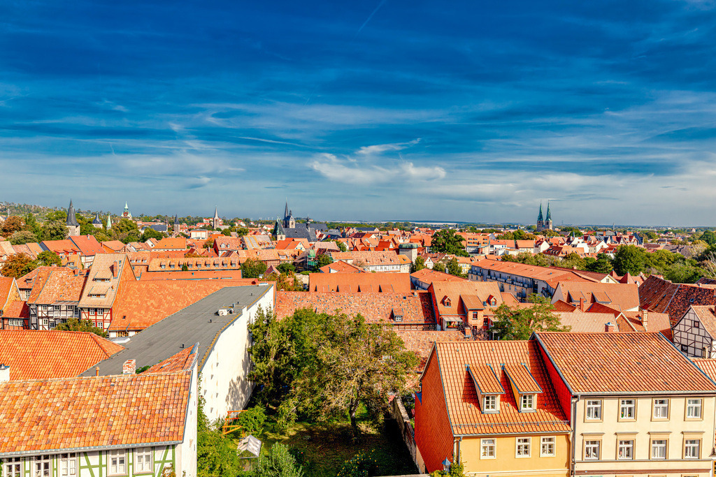 Herrliche Aussicht über Quedlinburg von Oben------Panorama | Das Bild zeigt einen Blick über die historische Altstadt von Quedlinburg, eine Welterbestadt im Harzvorland in Sachsen-Anhalt. Quedlinburg wurde 1994 in die Liste des UNESCO-Weltkulturerbes aufgenommen. Die Stadt ist für ihren bemerkenswerten Bestand von über 2.100 Fachwerkhäusern aus acht Jahrhunderten bekannt. Im Hintergrund ist die historische Stiftskirche St. Servatius auf dem Schlossberg zu erkennen. Die Stadt gilt als eine der bedeutendsten mittelalterlichen Städte Deutschlands und war im 10. und 11. Jahrhundert ein zentraler Ort für deutsche Könige und Kaiser.  - Realisiert mit Pictrs.com
