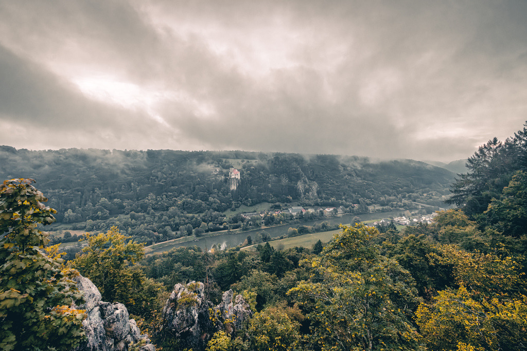 Blick in das malerische Altmühltal in Bayern,bewaldete Felsenlandschaft,Riedenburg | Das Bild zeigt das malerische Altmühltal in Bayern, fotografiert vom Aussichtspunkt Felsenklamm in der Nähe von Riedenburg.Zentrales Highlight: Inmitten der dicht bewaldeten Hügelkette auf der gegenüberliegenden Kanalseite thront die historische Burg Prunn, die auf einem steilen, frei stehenden Jurafelsen erbaut wurde.Im Tal verläuft der Main-Donau-Kanal, der sich harmonisch durch die bewaldete Felsenlandschaft schlängelt - Realisiert mit Pictrs.com
