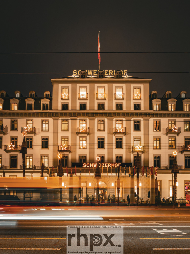 Schweizerhof Lichterglanz | Tradition. Lichter. Dynamik.
Das prächtige Hotel Schweizerhof in Luzern erstrahlt in festlichem Glanz, während die vorbeiziehenden Lichter der Stadt dynamische Spuren in die Nacht zeichnen. Ein faszinierendes Zusammenspiel aus historischer Eleganz und urbanem Puls zur Weihnachtszeit. - Realisiert mit Pictrs.com