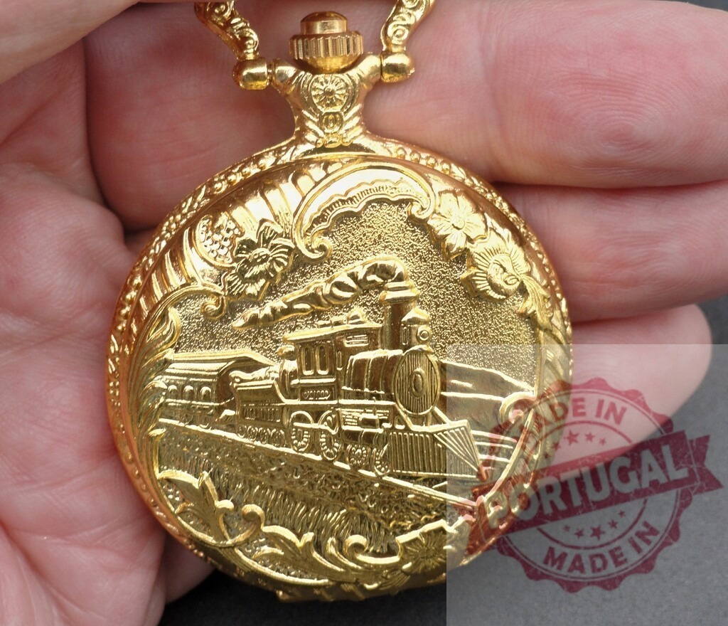 Gold pocket watch featuring vintage steam train engraving | Hand holding a decorative golden pocket watch with an embossed locomotive design - Realisiert mit Pictrs.com