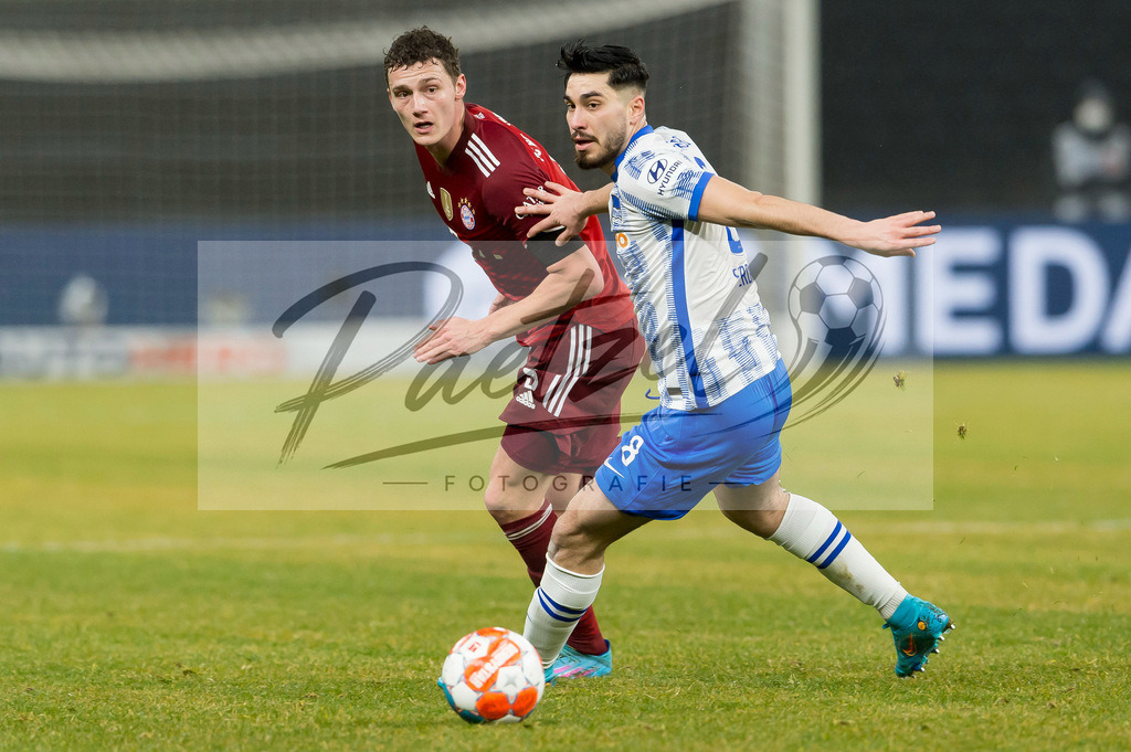 BSCFCB20220123_090 | Fussball, Herren: Benjamin Pavard (FC Bayern Muenchen) und Suat Serdar (Hertha BSC) im Zweikampf bei dem Spiel der 1. Bundesliga zwischen Hertha BSC und FC Bayern Muenchen im Olypiastadion am 23.01.2022 in Berlin, Deutschland.DFB / DFL REGULATIONS PROHIBIT ANY USE OF PHOTOGRAPHS AS IMAGE SEQUENCES AND/OR QUASI-VIDEO. - Realisiert mit Pictrs.com