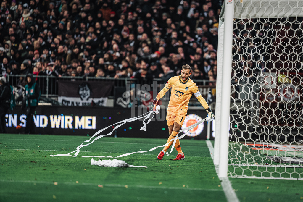 Fußball | Männer | Saison 2024/2025  | Fußball-Bundesliga | 26. Spieltag | FC St. Pauli vs. TSG Hoffenheim | 14.03.2025 | Oliver Baumann (#1, TSG Hoffenheim) räumt Papierrollen vom Feld
