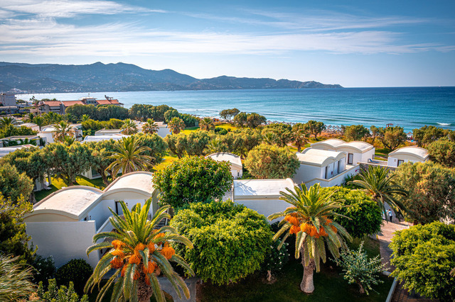 2026-07-24_16-57-47_740 | Weitblick über Gebäude und Palmen hin zum blauen Meer und den angrenzenden Hügeln bei klarem Wetter, Heraklion, Kreta, Griechenland - Realisiert mit Pictrs.com