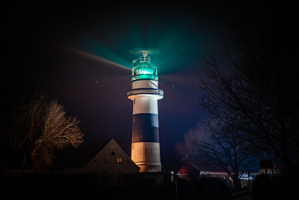 Leuchtturm Bülk | Das Bild zeigt den imposanten Leuchtturm Bülk, der sich an der nördlichen Landspitze der Kieler Förde erhebt. Der Leuchtturm ragt hoch in den Nachthimmel und dominiert die umliegende Landschaft mit seiner beeindruckenden Größe.
Das Bild vermittelt ein Gefühl von Ruhe und Frieden. Die Szenerie lädt dazu ein, in Gedanken auf eine Reise durch die Geschichte und Traditionen der Region zu gehen.