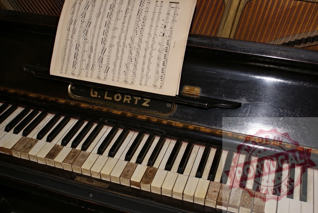 Old G.Lortz piano with sheet music and worn keys showing signs of age | Close-up of an old G.Lortz piano with sheet music and worn keys, creating a nostalgic and melancholic atmosphere - Realisiert mit Pictrs.com
