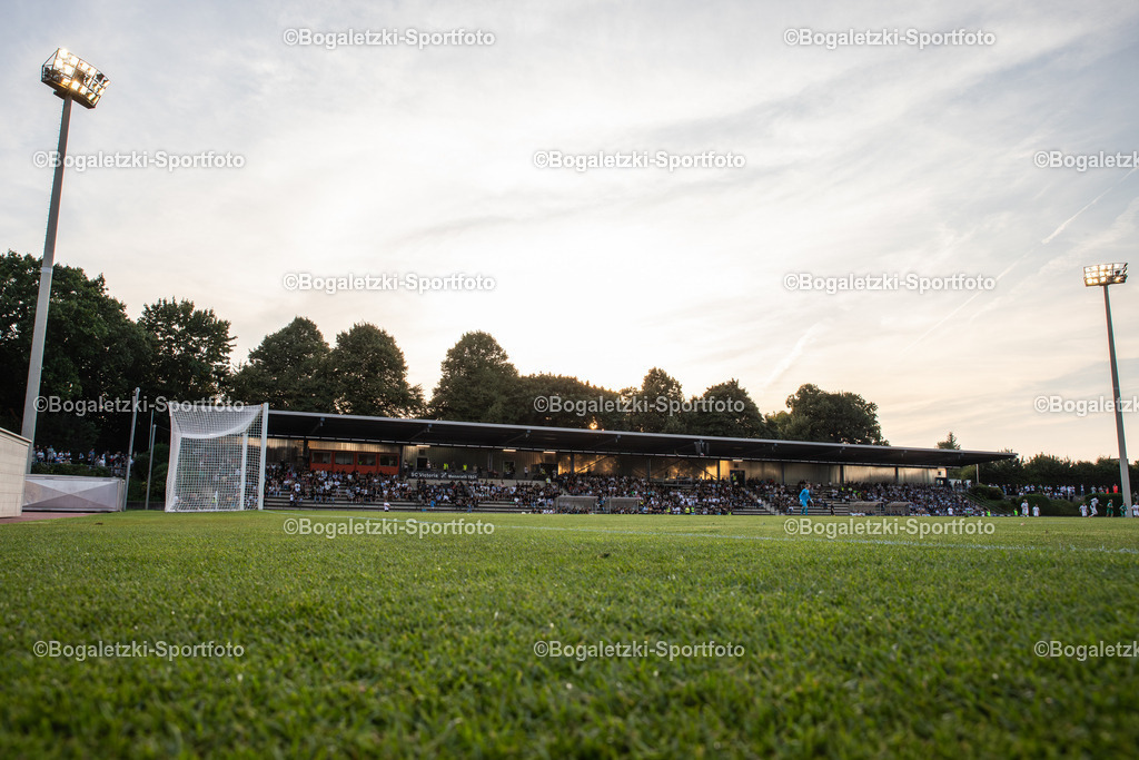 Grenzlandstadion Mönchengladbach | Grenzlandstadion: Tiefer Blick über das Spielfeld auf die Haupttribüne unter Flutlicht und Abendsonne - Realisiert mit Pictrs.com