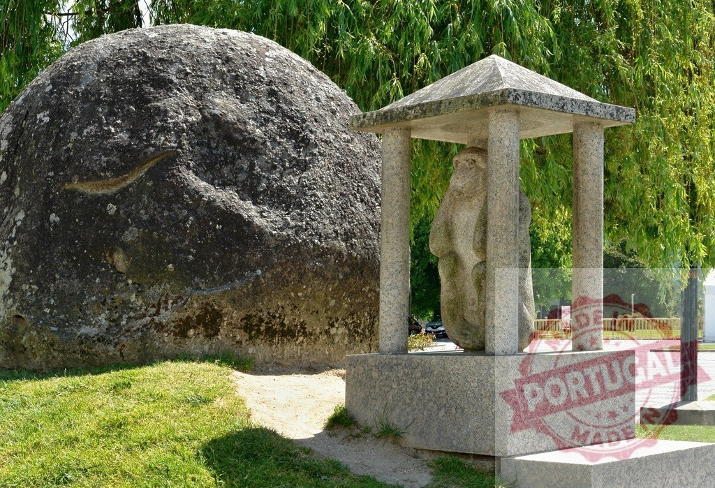 Stone sculptures in outdoor park with granite monument. Portugal - Norte | Stone sculpture resembling a monk standing under a granite canopy next to a large rock - Realisiert mit Pictrs.com