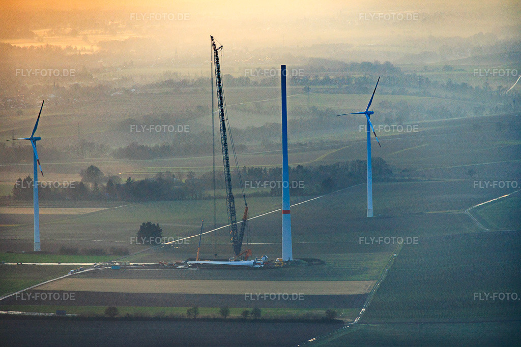 Luftbild: Sonnenuntergang beim Repowering des Windpark Minfeld. JUWI ersetzt vier Altanlagen (GE 1.5) aus 2004 durch zwei neue, modernen Anlagen vom Typ Vestas V162 mit je sechs MW in Minfeld im Bundesland Rheinland-Pfalz in Deutschland. Foto: IMG_152150.jpg vom 12.12.2025 durch Werner Riehm/FLY-FOTO.deJUWI Windparks - JUWI