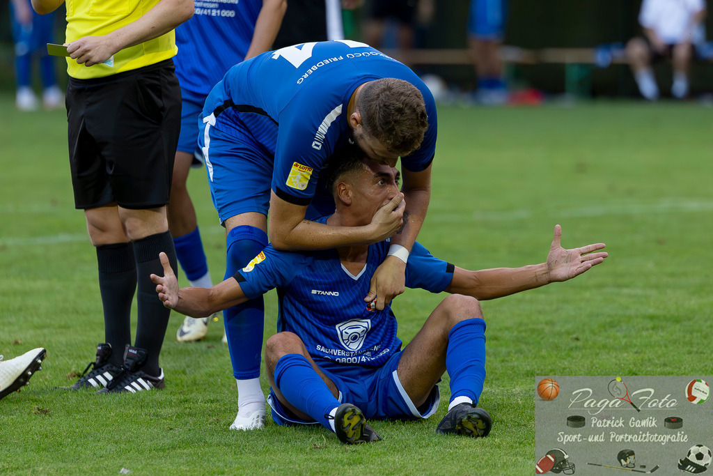 Hessenliga: Türk Gücü Friedberg - FC Eddersheim, 09.08.2024 | Toni Reljic (Türk Gücü Friedberg #44) hält Kamil Yikilmaz (Türk Gücü Friedberg #7) den Mund zu, damit weniger gemeckert und beschwert wird, weil sehr viele Emotionen nach dem Foulspiel entstanden sind, Türk Gücü Friedberg - FC Eddersheim, Friedberg, Städtischer Sportplatz, 9.8.2024 - Realisiert mit Pictrs.com