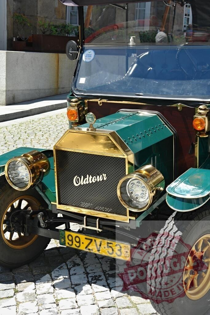Green and gold vintage car parked on cobblestone street | Shiny green and gold vintage car parked on a cobblestone street, offering a nostalgic glimpse into the past - Realisiert mit Pictrs.com