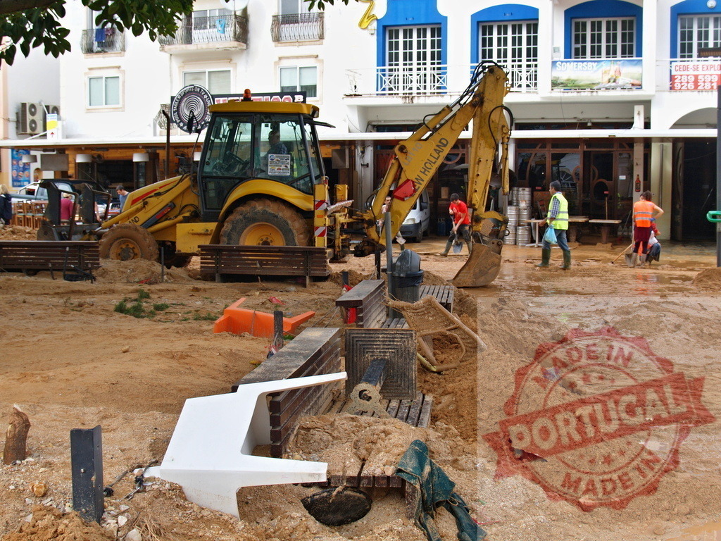 Workers cleaning up mud after natural disaster flood | Albufeira Flood - discruction by weather problems Cleanup operation in a town square after a devastating flood, removing thick mud and debris - Realisiert mit Pictrs.com