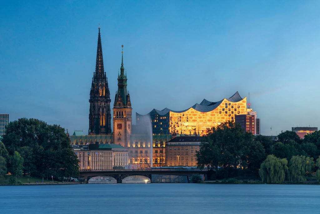 10230823 - Goldene Elbphilharmonie | Wunderschöner Blick über die Aussenalster auf eine im Abendlicht leuchtende Elbphilharmonie, das Rathaus und die Nikolaikirche.