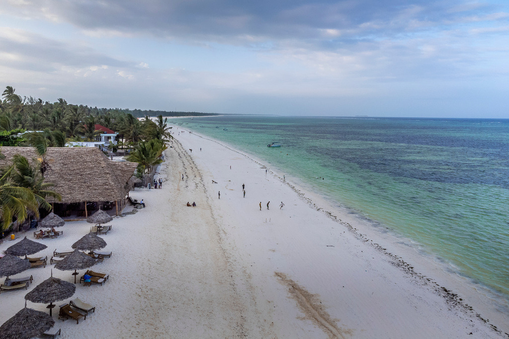 Zanzibar’s Endless Beach | An aerial view of Zanzibar’s serene beach, where soft white sand meets the vibrant, turquoise waters of the Indian Ocean.