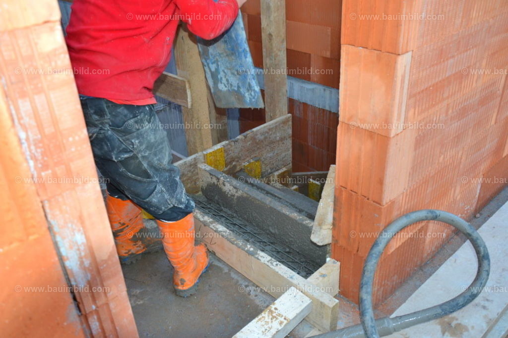 Betontreppe betonieren  | Arbeiter beim Betonieren einer geschalten und bewehrten Betontreppe in Ziegelmassivhaus