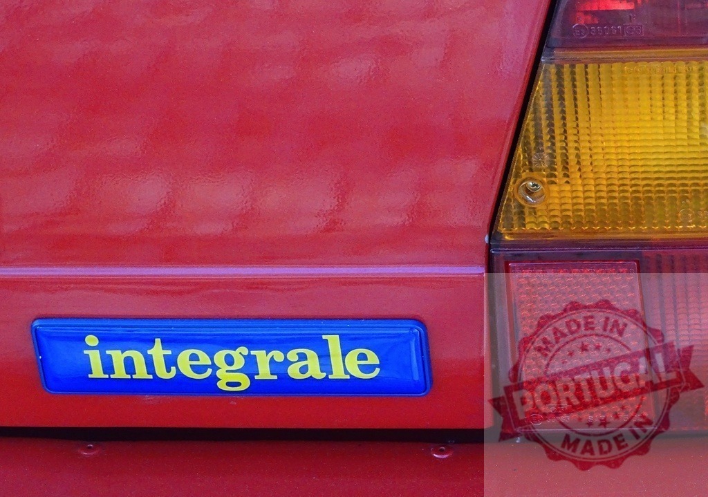 Lancia Delta HF Integrale badge and taillight | Red Lancia Delta HF Integrale car showing the badge and rear light details - Realized with Pictrs.com