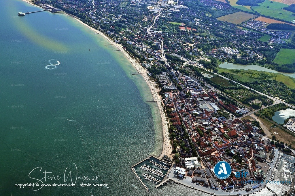 Luftbild Eckernförde - Die Stadt verfügt über eine reiche kulturelle und historische Landschaft | Die Stadt verfügt über eine reiche kulturelle und historische Landschaft, die sich auch im Stadtmuseum und im Ostsee-Info-Center widerspiegelt. Im Ostsee-Info-Center kann man sich über das Leben in der Ostsee informieren und im großen Fühlbecken Seesterne und Fische streicheln – ein besonderes Highlight für Familien und Kinder. Das Meerwasser-Wellenbad und die Sauna Hot Spot liegen direkt an der Strandpromenade und bieten das ganze Jahr über Bade- und Saunavergnügen. Für Naturliebhaber ist die Landzunge am Bülker Leuchtturm ein besonders schöner Ort, von dem aus man einen traumhaften Blick auf die Ostsee, die Steilküste und das dänische Wohld genießen kann.