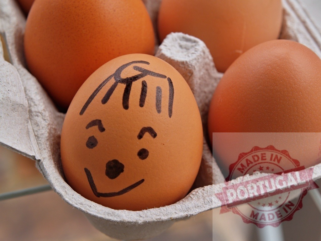 Drawing funny face on an egg in carton | Happy hand-drawn face on a brown egg sitting in an egg carton with other eggs - Realized with Pictrs.com