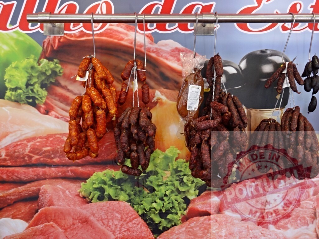 Sausages and chorizo hanging in a butcher shop display | Various types of sausages and chorizo hanging from hooks in a butcher shop - Realisiert mit Pictrs.com
