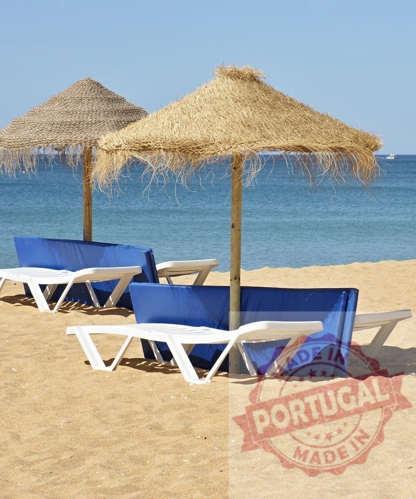 Thatched umbrellas providing shade for empty sunbeds | Sandy beach with straw umbrellas and blue folding sunbeds by the tranquil sea - Realized with Pictrs.com