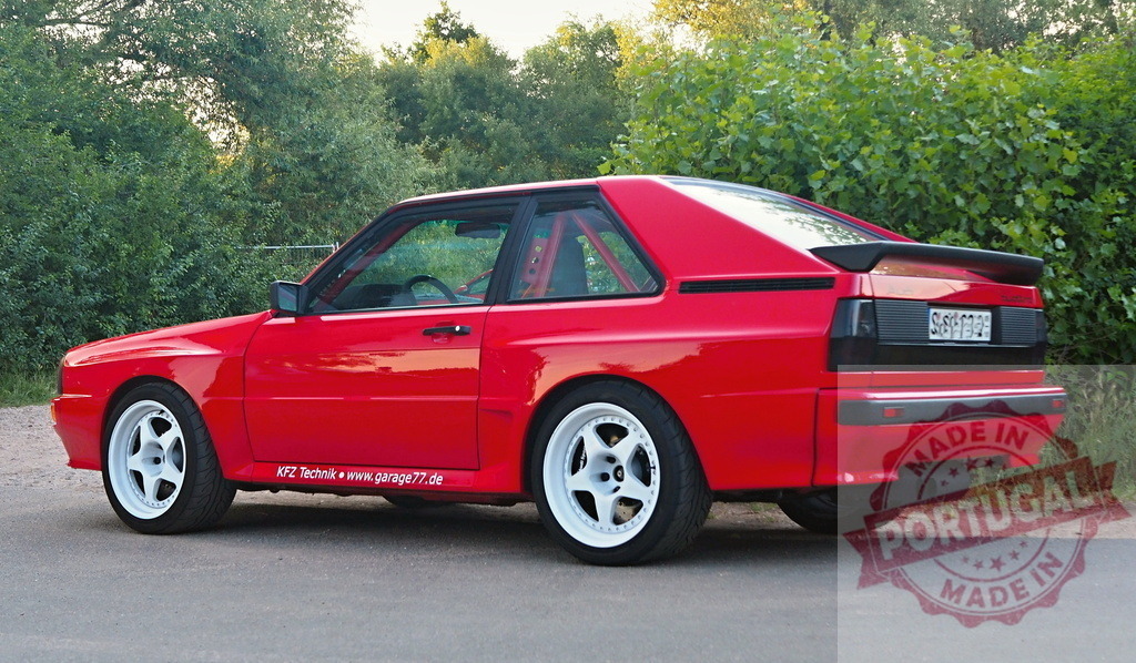 Red Audi Sport Quattro 1980s rally coupe street legal | Red Audi Sport Quattro classic rally car parked on asphalt roadside with green trees - Realisiert mit Pictrs.com