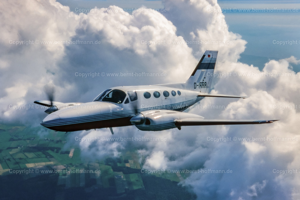 PLBDD_air2air_C421_01_90x60 | Luftbild. Zweimotoriges Geschäftsflugzeug ( Typ CESSNA 421 ) über den Wolken und zwischen Cumulus- Wolken im Luftraum zwischen Flensburg und Nordfriesland. ___ Das Foto ist eine Reproduktion von einem Farbdia.. - Realisiert mit Pictrs.com