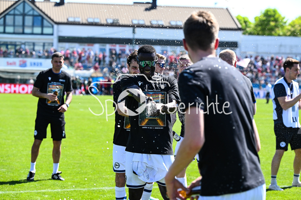 SpVgg Unterhaching - Arminia Bielefeld | die Mannschaft aus Bielefeld feiert zusammen mit den Fans dein Sieg und den Aufstieg in Unterhaching / Bierdursche / Bier / Freude / Happy / Gluecklich / 3. Liga: SpVgg Unterhaching - Arminia Bielefeld, Uhlsport Park am 11.05.2025 / Merveille BIANKADI (Arminia Bielefeld 17)