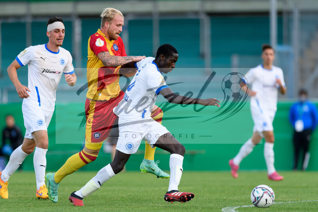LOTKSC20210809_037 | Fussball, Herren: Philipp Hofmann (Karlsruher SC) und Komlan Fionouke (Sportfreunde Lotte) im Zweikampf beim Spiel der 1. Runde im DFB-Pokal zwischen SF Lotte und Karlsruher SC im Stadion am Lotter Kreuz am 09.08.2021 in Lotte, Deutschland.DFB / DFL REGULATIONS PROHIBIT ANY USE OF PHOTOGRAPHS AS IMAGE SEQUENCES AND/OR QUASI-VIDEO. - Realisiert mit Pictrs.com