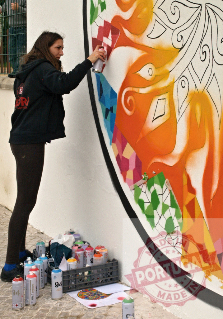 Street artist painting colorful mural on a wall | Street artist using spray paint to create vibrant artwork on a public wall - Realized with Pictrs.com