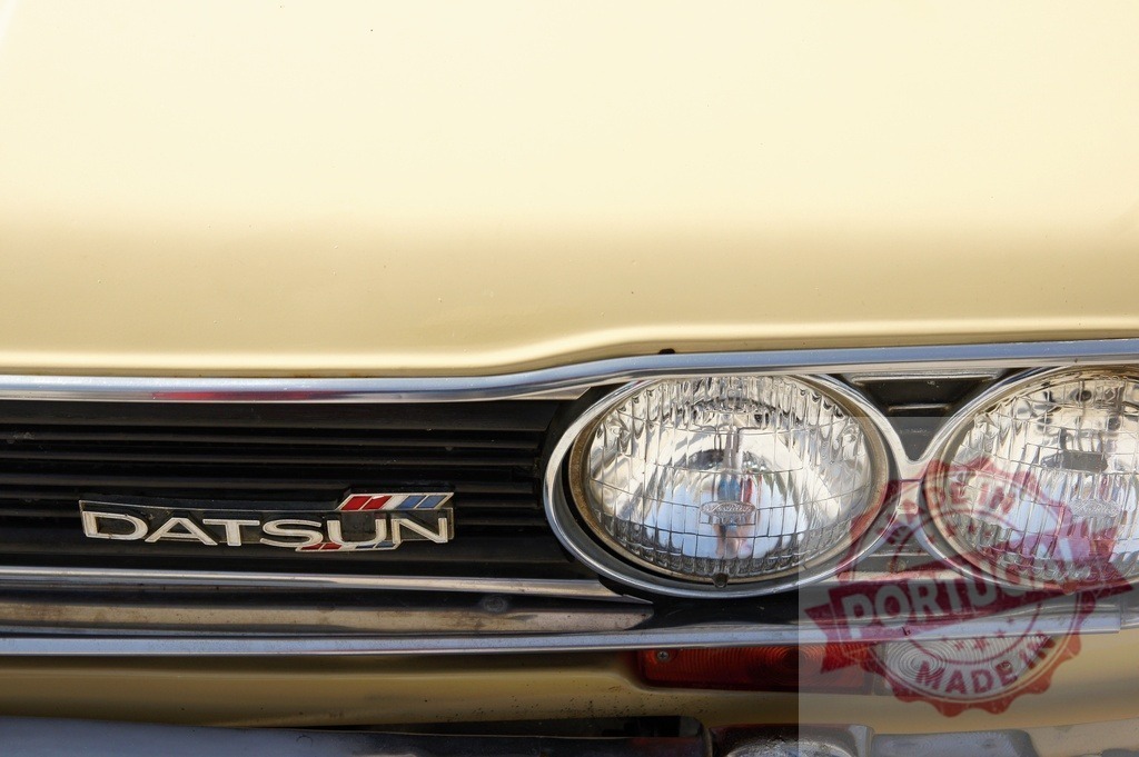 Datsun car grille with classic headlights and logo | Datsun classic car showing chrome grille, vintage headlights, and retro branding detail - Realized with Pictrs.com