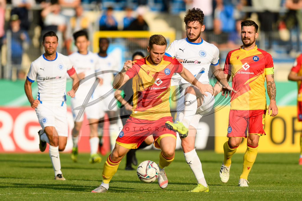 LOTKSC20210809_014 | Fussball, Herren: Christoph Kobald (Karlsruher SC) und Cedric Euschen (Sportfreunde Lotte) im Zweikampf beim Spiel der 1. Runde im DFB-Pokal zwischen SF Lotte und Karlsruher SC im Stadion am Lotter Kreuz am 09.08.2021 in Lotte, Deutschland.DFB / DFL REGULATIONS PROHIBIT ANY USE OF PHOTOGRAPHS AS IMAGE SEQUENCES AND/OR QUASI-VIDEO. - Realisiert mit Pictrs.com