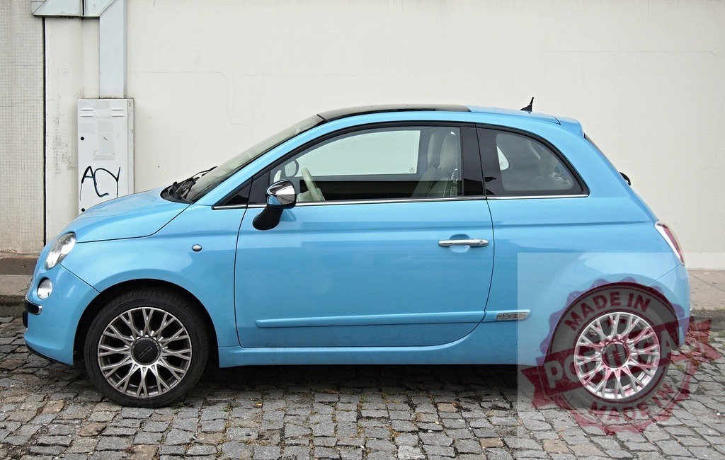 Fiat 500 light blue compact car parked on cobblestone street | Fiat 500 city car parked on old cobblestones next to a white wall - Realisiert mit Pictrs.com