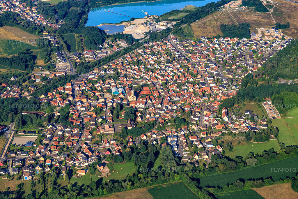 Aerial view: View of the town from the northeast, this side of the quarry lake in Kaltenhouse in the state Bas-Rhin, France. – Photo: IMG_082933.jpg taken on 06/26/2015 by Werner Riehm/FLY-FOTO.com – Resolution of the original: 5472 x 3648 px