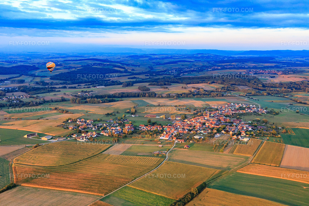 Aerial view: Hot air balloon over the village in Kindwiller in the state Bas-Rhin, France. – Photo: IMG_117780.jpg taken on 09/14/2019 by Werner Riehm/FLY-FOTO.com – Resolution of the original: 5472 x 3648 px
